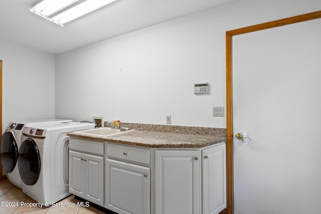 washroom with cabinets, independent washer and dryer, sink, and light tile patterned floors