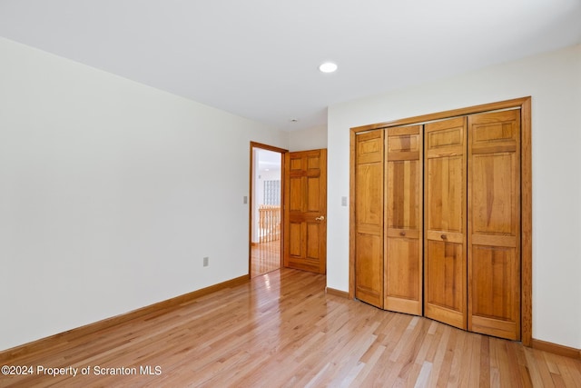 unfurnished bedroom featuring a closet and light hardwood / wood-style floors