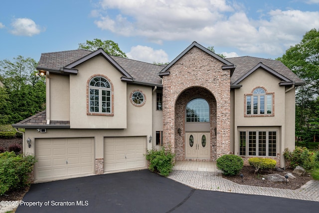 133 Glenmaura Dr, Moosic, PA 18507 - view of front of house with stucco siding, asphalt driveway, an attached garage, and brick siding