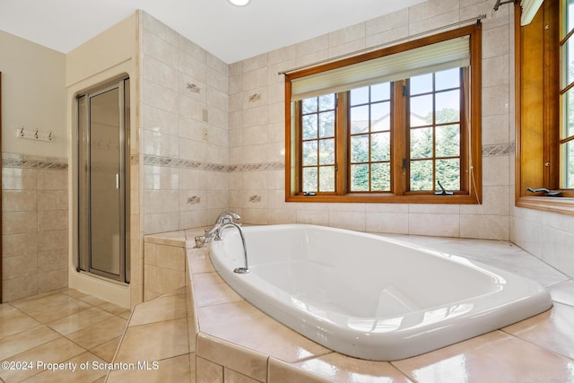 bathroom featuring tile patterned flooring, tile walls, and independent shower and bath