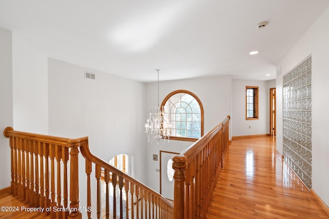 hall featuring a notable chandelier and light hardwood / wood-style floors