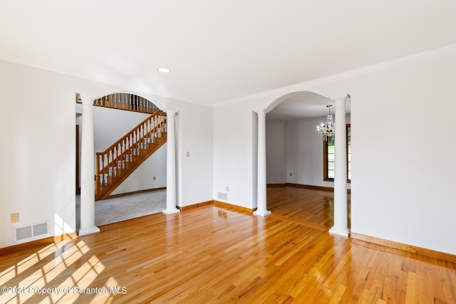 unfurnished room with hardwood / wood-style flooring, an inviting chandelier, and ornamental molding