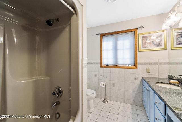 full bathroom with vanity, bathing tub / shower combination, tile patterned flooring, toilet, and tile walls