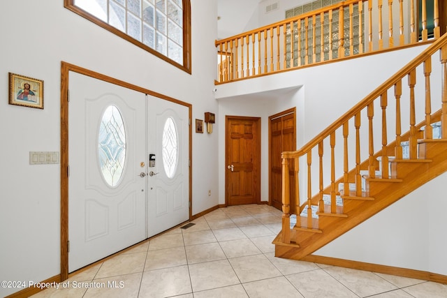 tiled foyer entrance featuring a towering ceiling