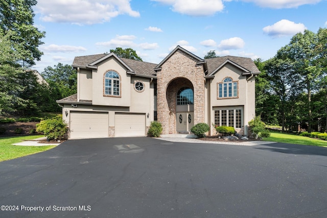 133 Glenmaura Dr, Moosic, PA 18507 - view of front of house featuring a garage, stucco siding, and asphalt driveway