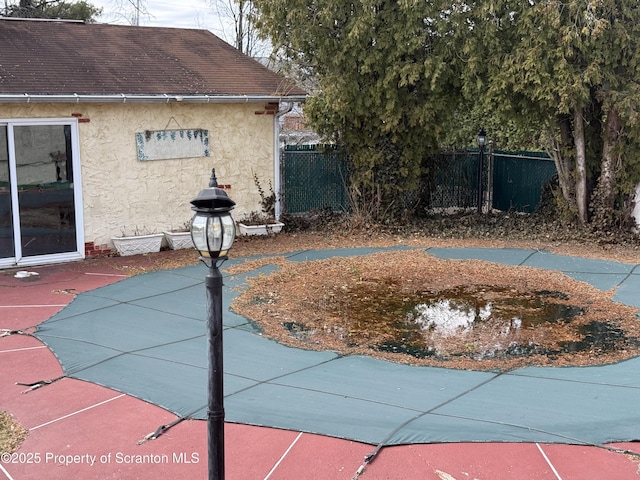 view of swimming pool featuring a patio and fence