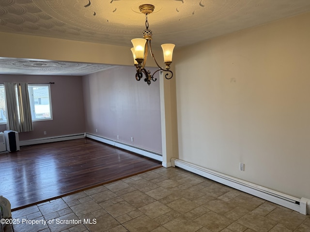 empty room featuring baseboard heating, stone finish floor, baseboards, and an inviting chandelier