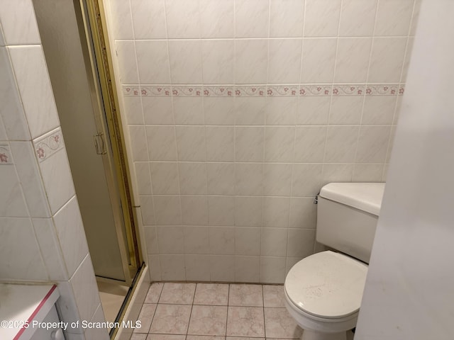 full bathroom featuring toilet, tile walls, a shower stall, and tile patterned flooring