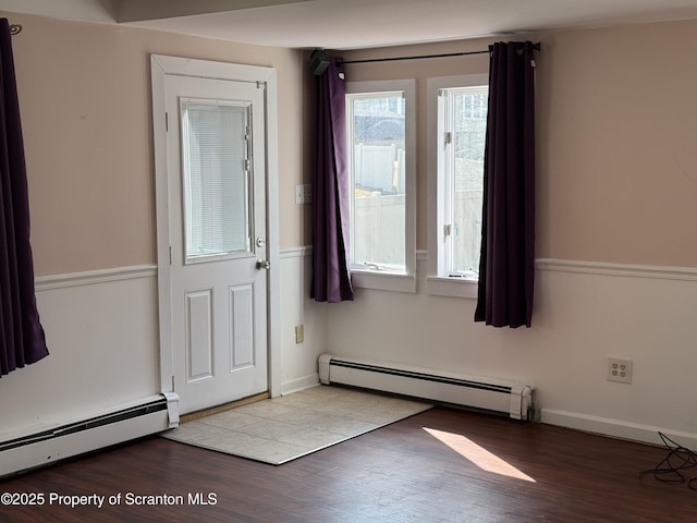 entryway with baseboards, baseboard heating, and wood finished floors