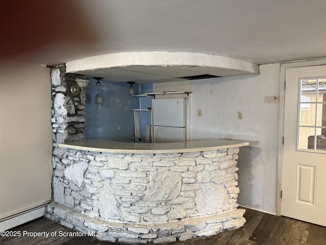 kitchen featuring baseboard heating, wood finished floors, and freestanding refrigerator