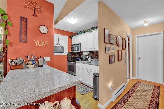 13 S Lehigh River Dr, Clifton Twp, PA 18424 - kitchen with appliances with stainless steel finishes, a baseboard radiator, light wood-style floors, a sink, and white cabinets