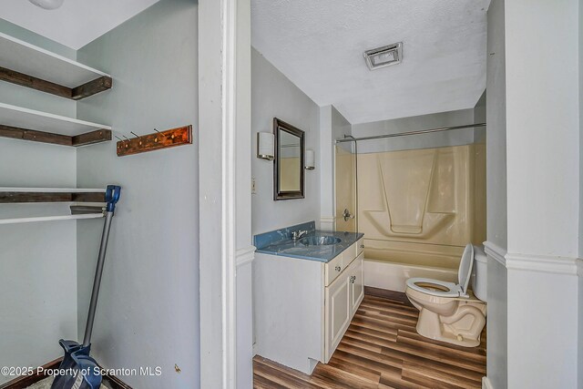 full bathroom featuring vanity, visible vents, wood finished floors, toilet, and shower / bathing tub combination