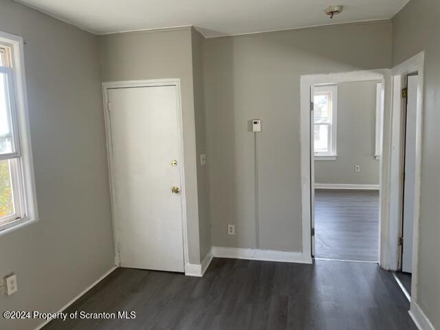 unfurnished room with dark wood-type flooring