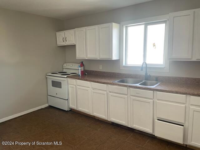 kitchen featuring sink, white cabinets, and white electric stove