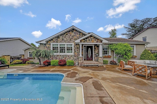 214 Oak St, Dunmore, PA 18512 - rear view of property featuring stone siding, an outdoor pool, a patio, and an outdoor hangout area