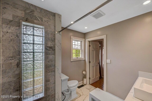214 Oak St, Dunmore, PA 18512 - bathroom featuring marble finish floors, a tile shower, toilet, baseboards, and vanity