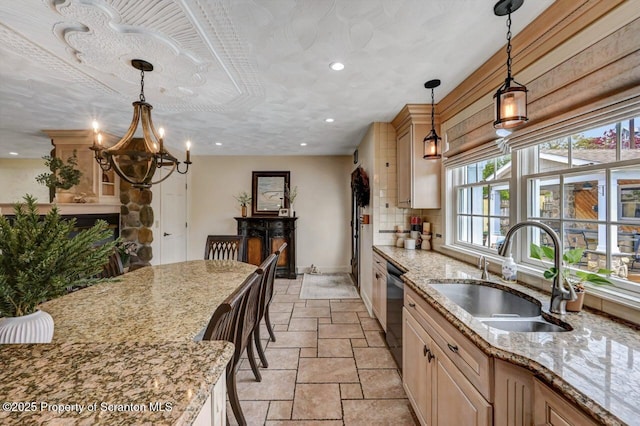 214 Oak St, Dunmore, PA 18512 - kitchen with a sink, stainless steel dishwasher, stone tile floors, a chandelier, and light stone counters
