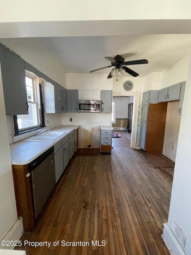 kitchen with dark wood-type flooring, gray cabinets, stainless steel appliances, and light countertops