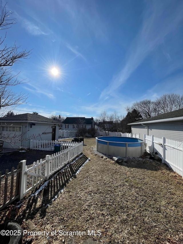 view of yard featuring fence and an outdoor pool