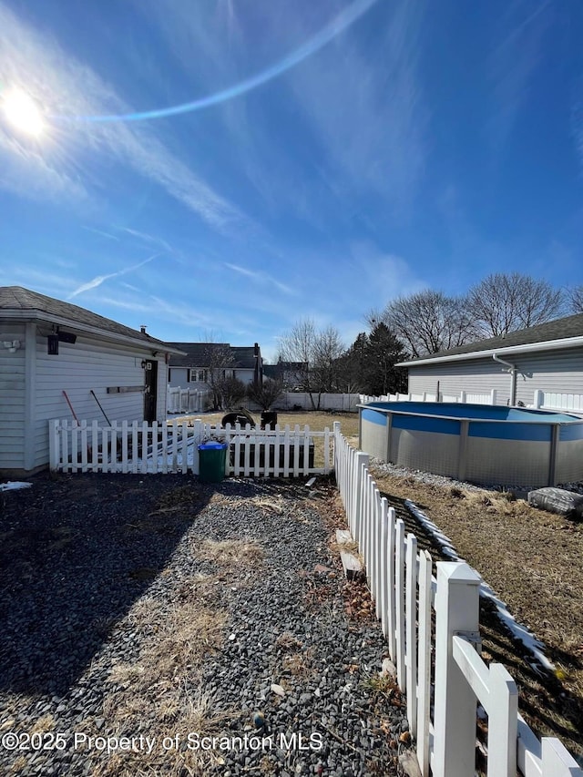 view of yard with fence and an outdoor pool