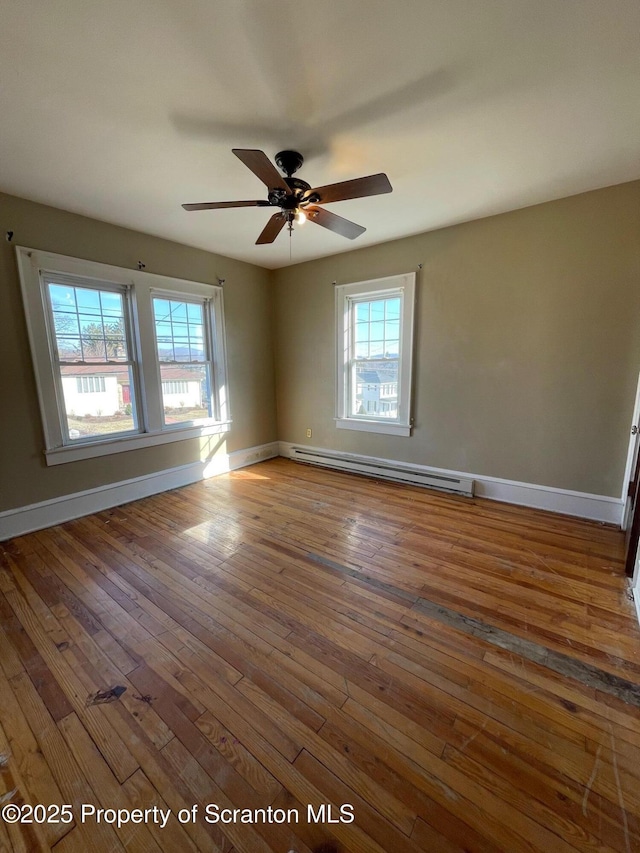 spare room featuring a baseboard radiator, wood-type flooring, ceiling fan, and baseboards