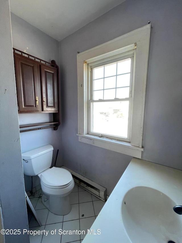 bathroom featuring a baseboard heating unit, vanity, toilet, and tile patterned floors