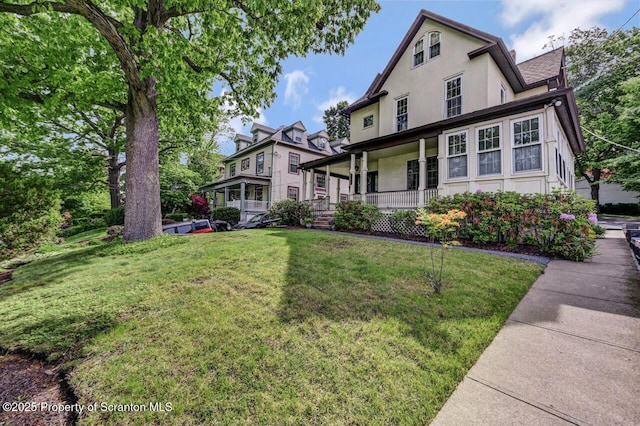 1614 Jefferson Ave, Dunmore, PA 18509 - view of front of home with a porch, stucco siding, a front yard, and roof with shingles