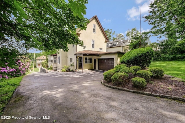 1614 Jefferson Ave, Dunmore, PA 18509 - view of front of home featuring stucco siding, asphalt driveway, and a garage