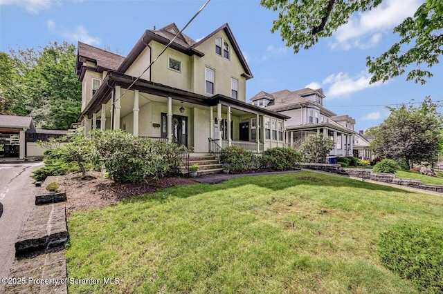1614 Jefferson Ave, Dunmore, PA 18509 - view of front facade featuring stucco siding, a porch, and a front yard