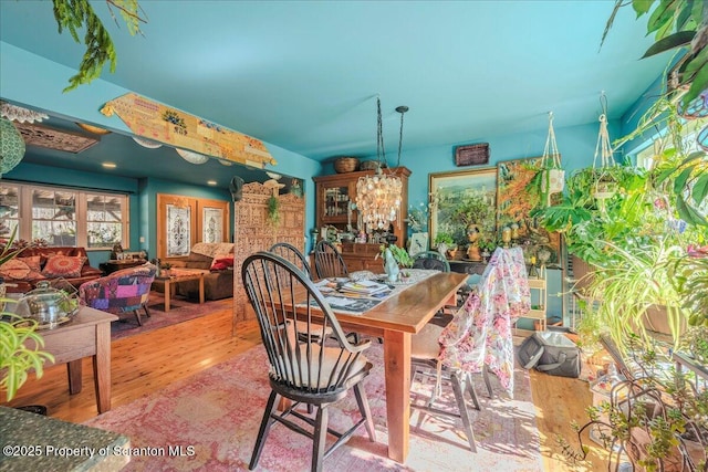 2119 Vacation Ln, Pocono Summit, PA 18346 - dining space with wood finished floors, a chandelier, and healthy amount of natural light