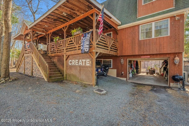 2119 Vacation Ln, Pocono Summit, PA 18346 - view of property exterior featuring an attached garage, roof with shingles, stairway, and driveway