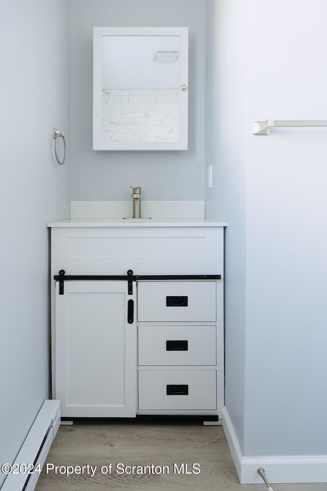 bathroom featuring baseboard heating and vanity