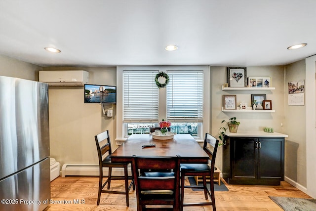 dining room featuring a baseboard radiator, light wood-type flooring, and a wall mounted AC