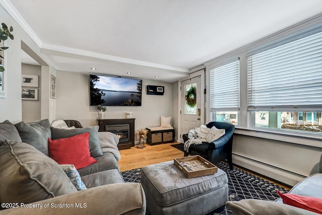 living room with hardwood / wood-style flooring, baseboard heating, and ornamental molding