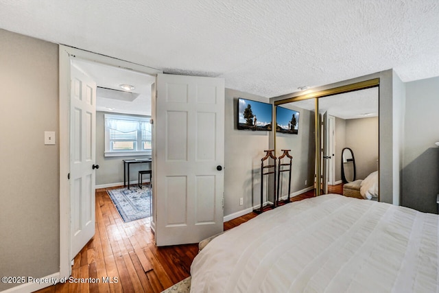 bedroom featuring a closet, a textured ceiling, and dark hardwood / wood-style flooring