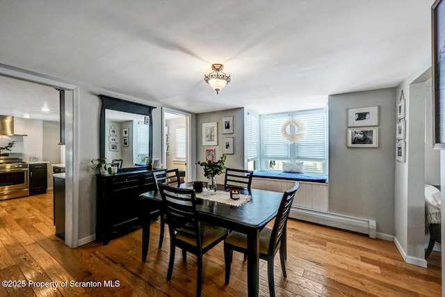 dining area featuring hardwood / wood-style flooring and a baseboard heating unit