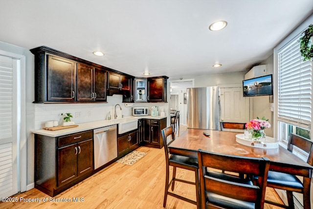 kitchen with sink, light wood-type flooring, a wealth of natural light, and appliances with stainless steel finishes