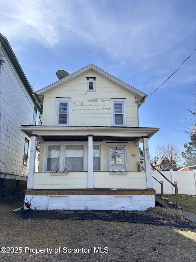 back of property with covered porch and fence