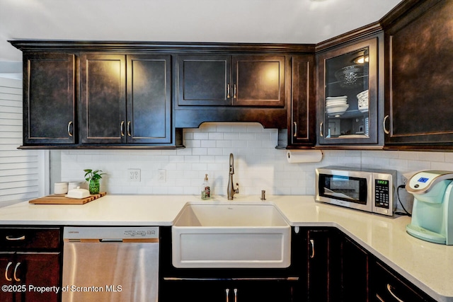 kitchen featuring sink, dark brown cabinets, backsplash, and appliances with stainless steel finishes