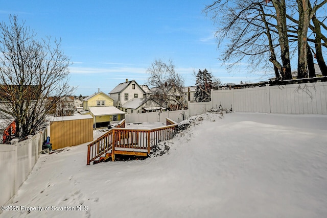 snowy yard with a deck