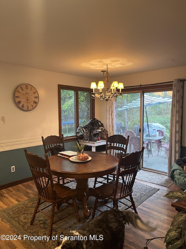 dining space with wood-type flooring and a chandelier