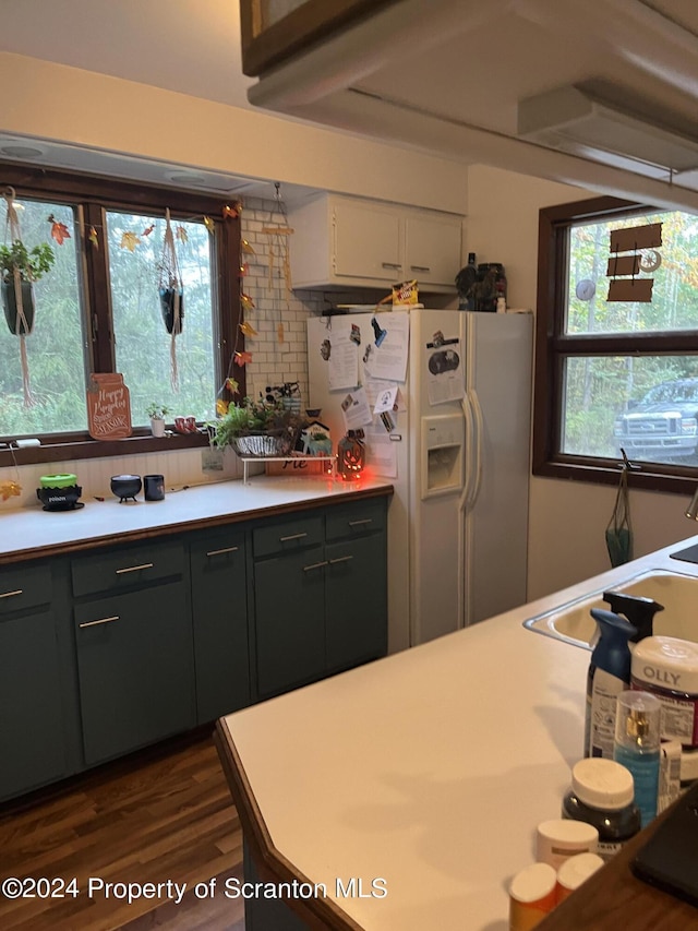 kitchen with white cabinetry, dark wood-type flooring, plenty of natural light, and white fridge with ice dispenser