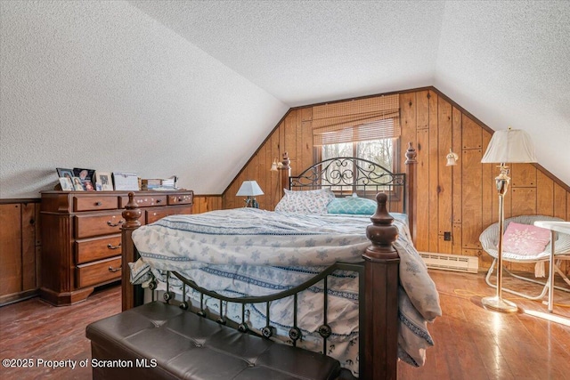 bedroom with wood-type flooring, vaulted ceiling, a textured ceiling, and wooden walls