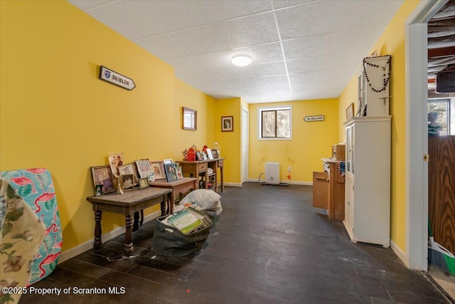 misc room featuring dark wood-type flooring and a drop ceiling