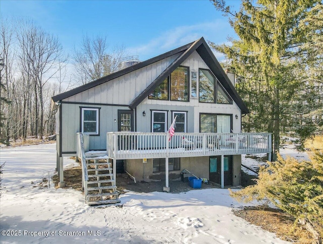 snow covered rear of property with a wooden deck