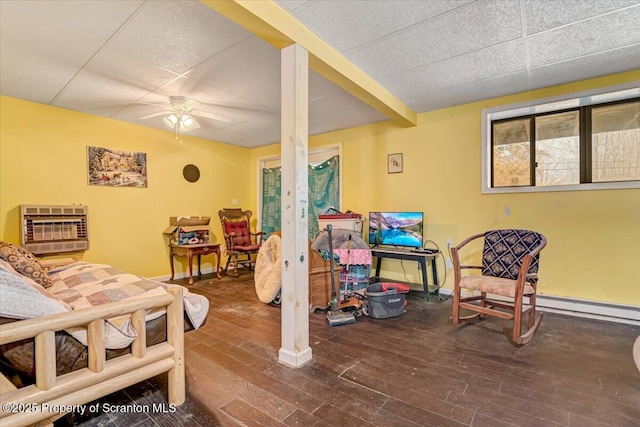 living area featuring wood-type flooring, a paneled ceiling, heating unit, and ceiling fan