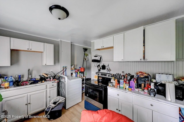612 Farber Ct, Scranton, PA 18510 - kitchen with stainless steel range with electric stovetop, washer / clothes dryer, light countertops, white cabinetry, and light wood-type flooring