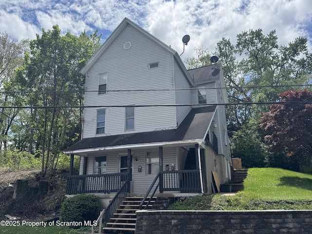 view of front of home with stairway and a porch