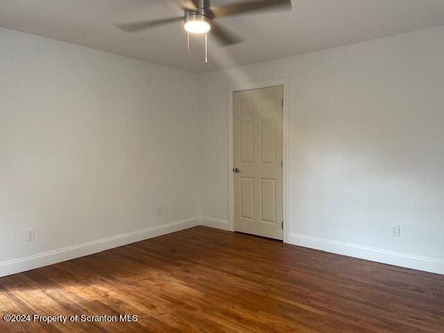 spare room with ceiling fan and dark wood-type flooring