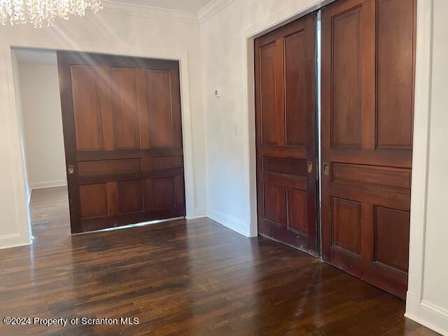 entryway with a chandelier, dark hardwood / wood-style flooring, and ornamental molding